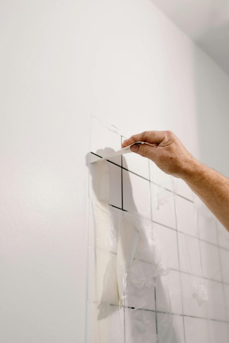 Crop anonymous male doing renovation works in room with tiled walls at home